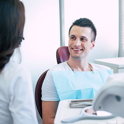Man smiling at dentist while sitting in treatment chair