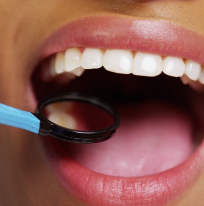 Dentist examining smile after metal free dental restoration