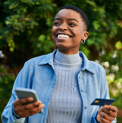 a smiling person holding their credit card in their hand