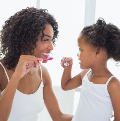 Mother and child brushing teeth to prevent dental emergencies