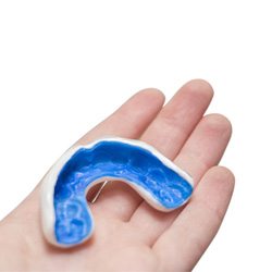 Close-up of a hand holding a mouthguard 