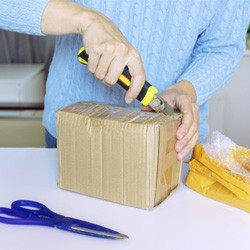 Opening a package with a knife; scissors on table