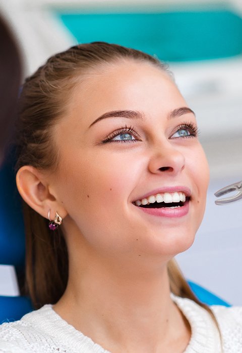 Dentist about to extract woman’s tooth with forceps
