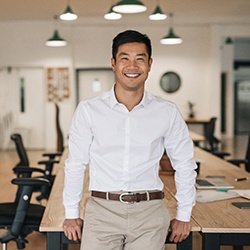 Man with dental implants in North Garland, TX smiling in office