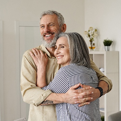 Older couple hugging and smiling at home