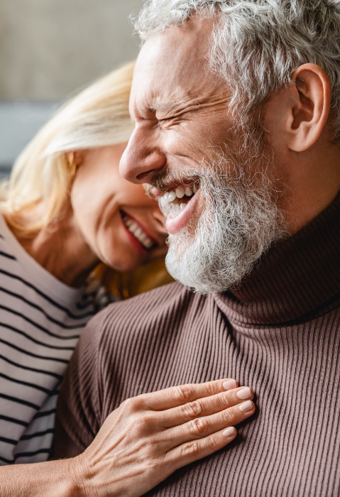 Man and woman smiling after dental implant tooth  replacement