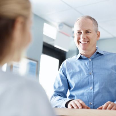 Man discussing cost of dental implants with dentistry team member