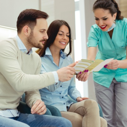 Dental team member giving patients dental insurance information