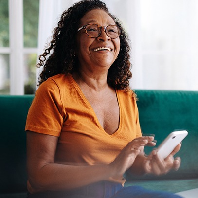 a woman smiling with her phone in her hands