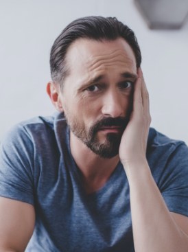 Man in need of emergency dentistry holding jaw