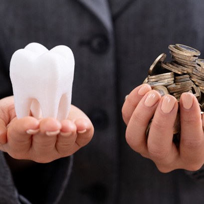 Woman’s hands holding large molar and coins