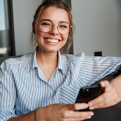 a smiling person with their phone in their hand