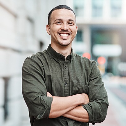 a smiling man with his arms crossed