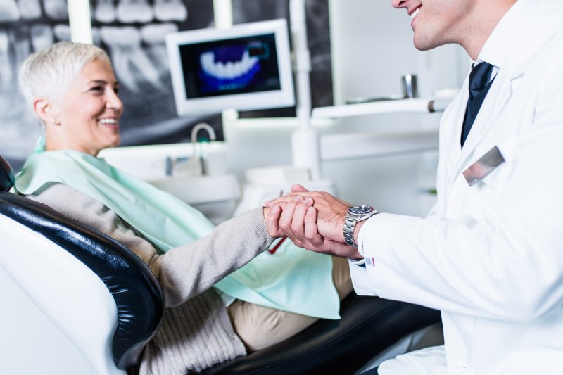 Dentist explaining how dental implants and rheumatoid arthritis are connected