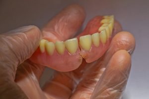 a person holding broken dentures